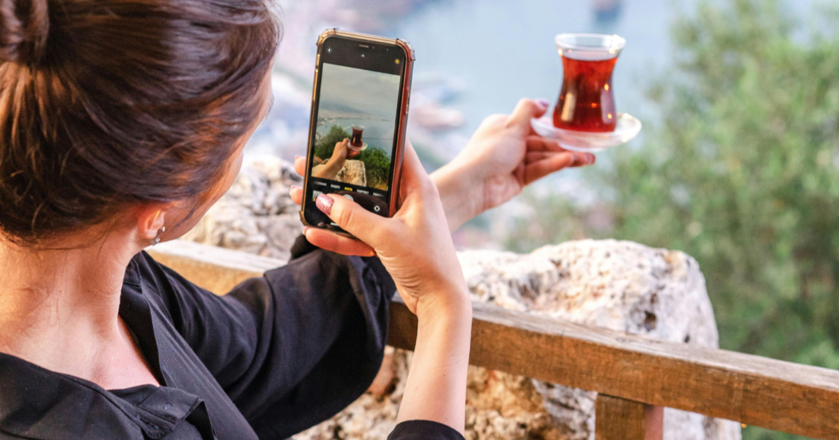 Chica tomando una foto de una bebida.