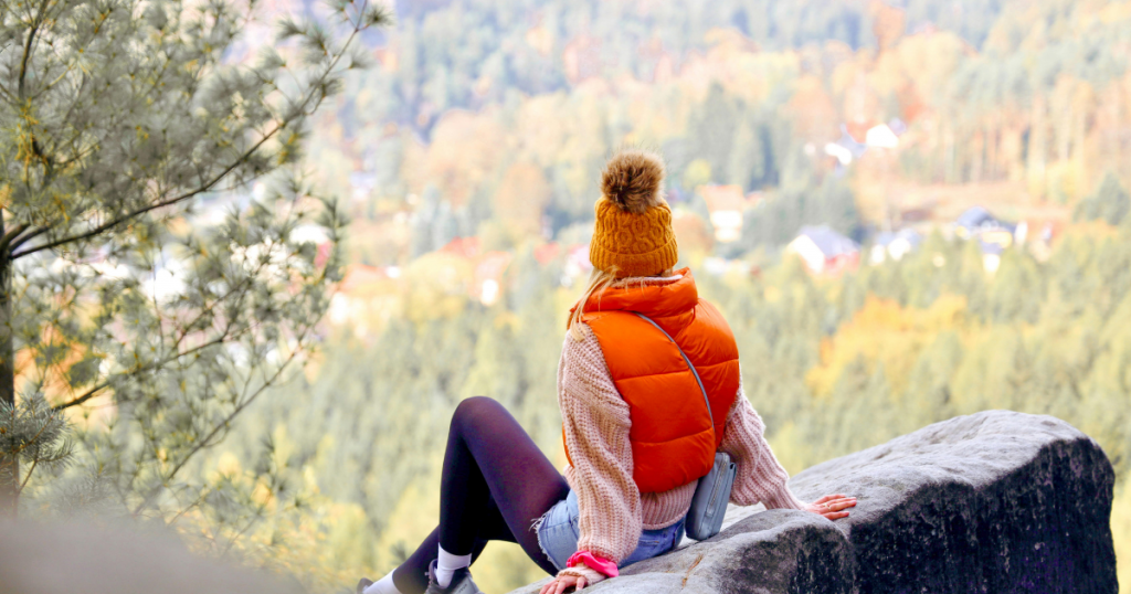 chica de espaldas observando bosque en otoño